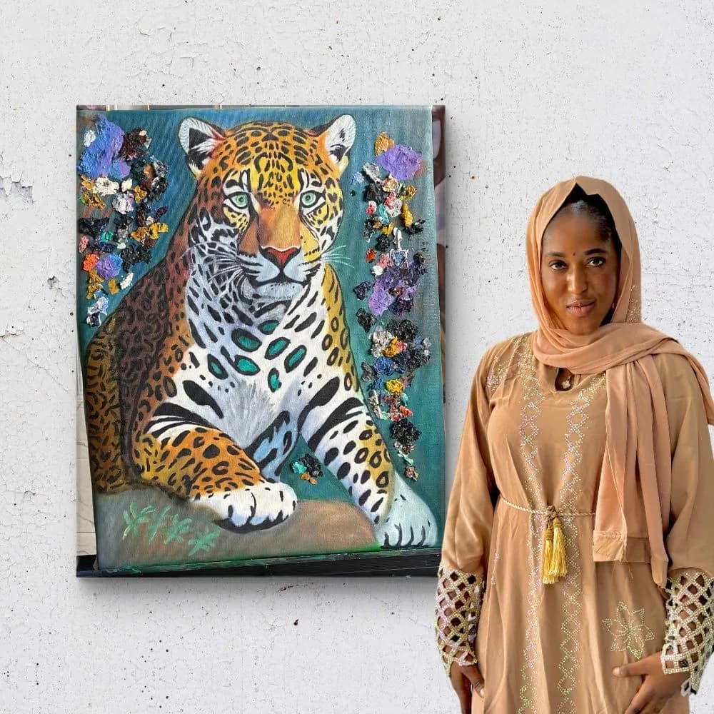 Finished leopard painting displayed beside its owner
